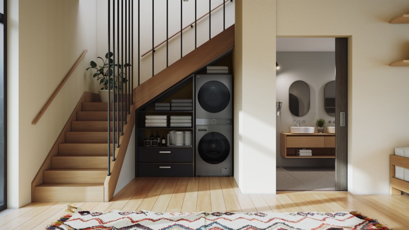 LG Washtower: lavadora y secadora unidas en un electrodoméstico minimalista integrado en un hueco bajo una escalera de madera de un hogar del mismo estilo en tonos neutros