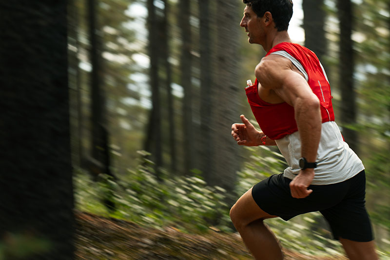 TicWatch Atlas: plano medio de una foto en movimiento en la que sale un hombre deportista corriendo en un paisaje natural con un TicWatch Atlas negro