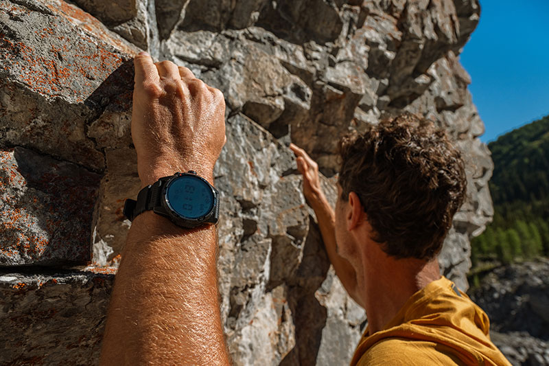 TicWatch Atlas: un hombre escala al sol una montaña con un TicWatch Atlas negro en su muñeca