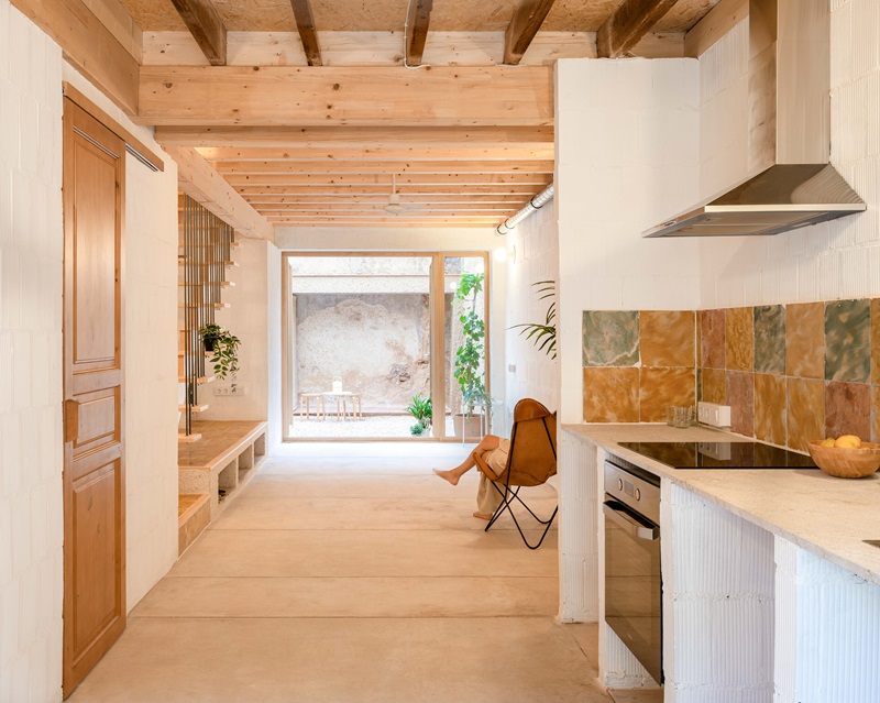 DRDRarquitectura-Viviendas-Arta: cocina, sala de estar con vigas de madera y patio vivienda