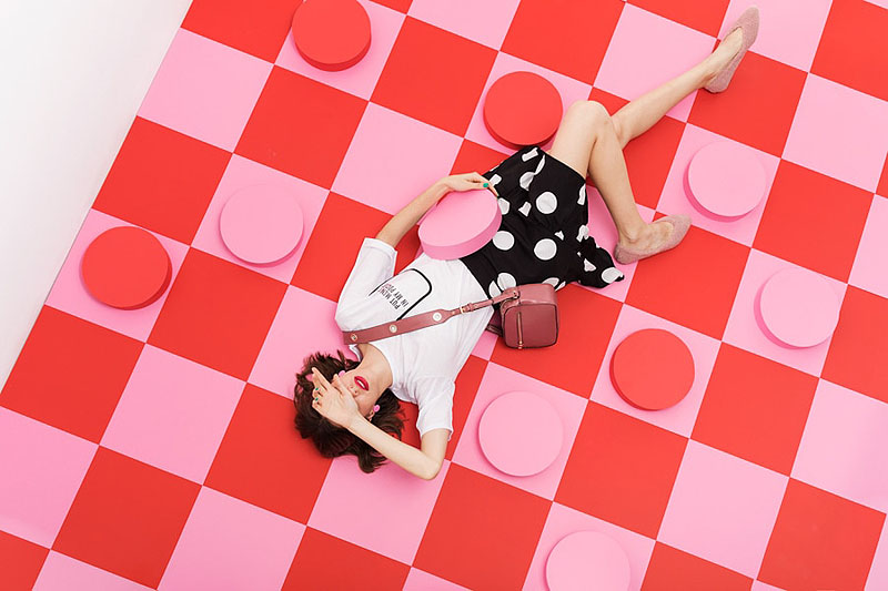 Mujer tumbada sobre una tabla de damas roja y rosa