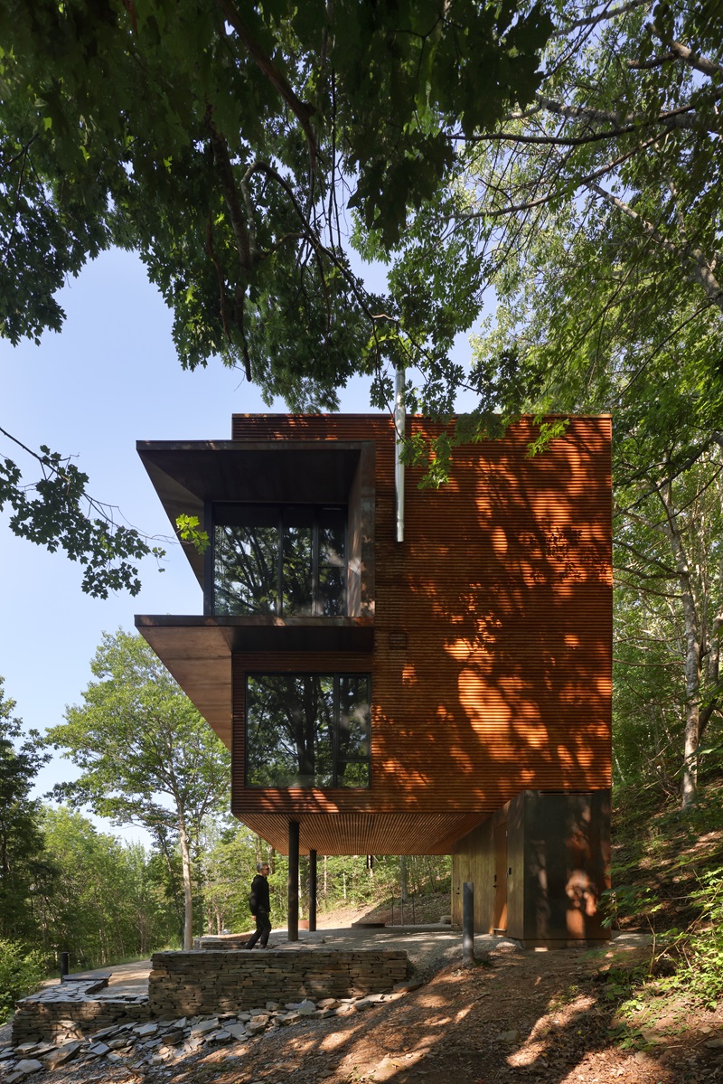 Omar-Gandhi-Architects-White-Rock: perfil vivienda de acero corten rodeada de árboles