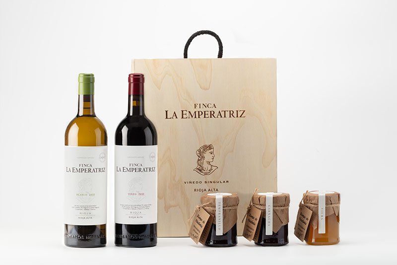 Finca La Emperatriz: Un set completo que incluye una caja de madera personalizada con el logotipo de Finca La Emperatriz, dos botellas de vino (una de tinto y otra de blanco 2018) y tres frascos de mermelada artesanal.