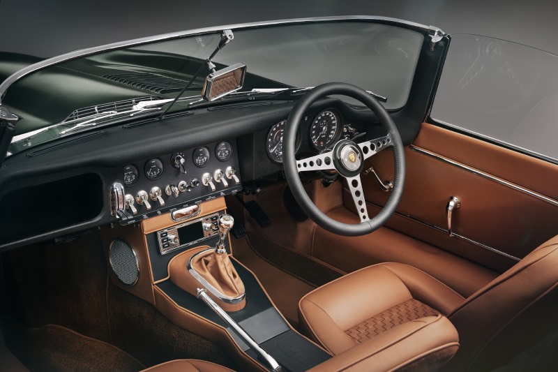 Jaguar Classic E-Type: interior del exclusivo Jaguar Classic E-Type con asientos en piel marrón y el volante junto a la parte delantera en negro con detalles de materiales de joyería