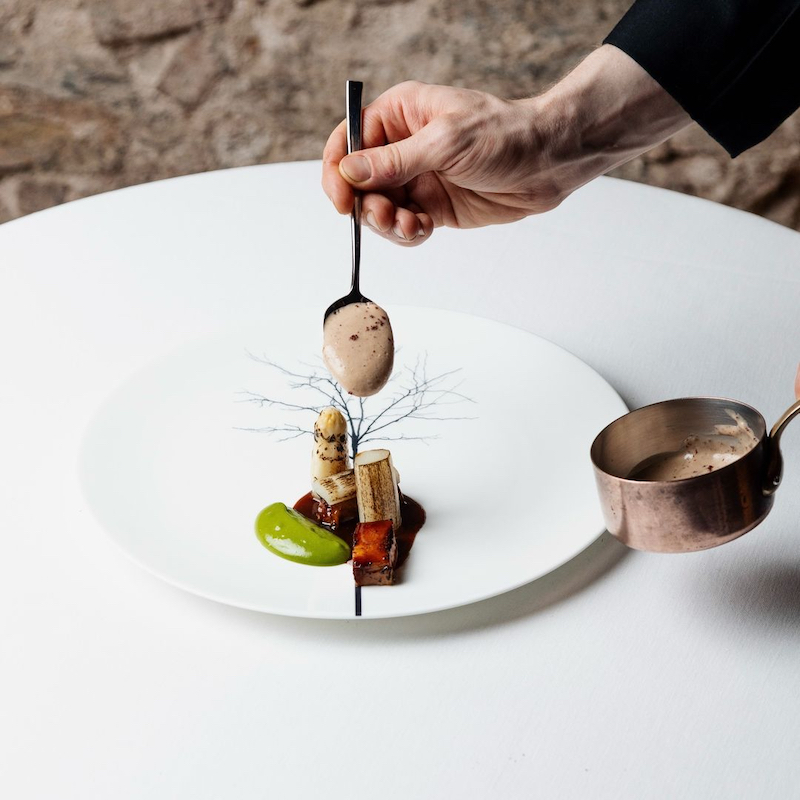 El restaurante más barato de Barcelona con Estrella Michelin: Espárrago blanco braseado acompañado de una mayonesa de wasabi fresco, papada de cerdo ibérico cocinada al estilo cantonés, emulsión de sumac y acabado con una flores de caléndula, de Prodigi