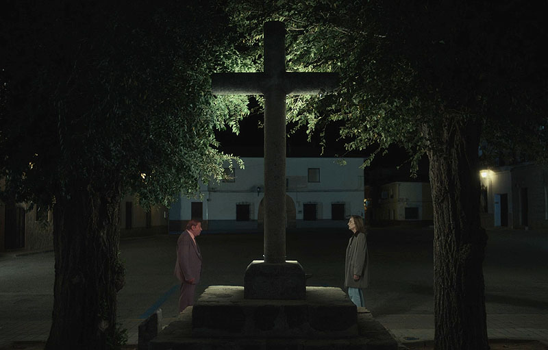 Bodegon con Fantasmas, fotograma de la película, se ve una cruz de piedra en una plaza de un pueblo iluminada por la noche