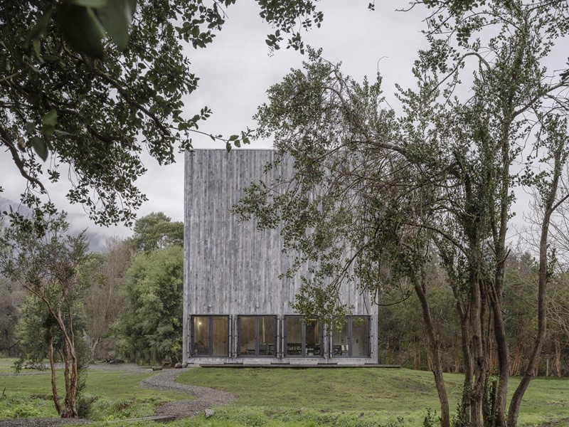 Iván-Bravo-Architects-Humo-House: casa de madera con forma de cubo y ventanales