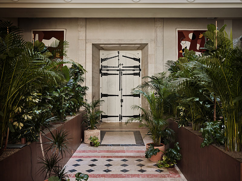 Restaurante Santa Joana Lisboa: una puerta tipo almacén rodeada de muchas plantas