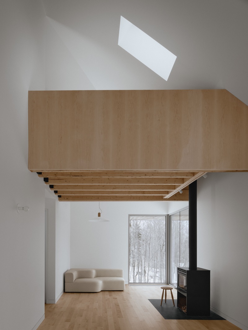 Julia-Manaças-Architecte-House-MN: sala de estar con altillo de madera comunicando con el salón