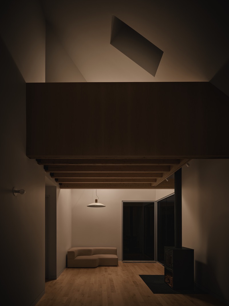 Julia-Manaças-Architecte-House-MN: sala de estar con altillo de madera comunicando con el salón