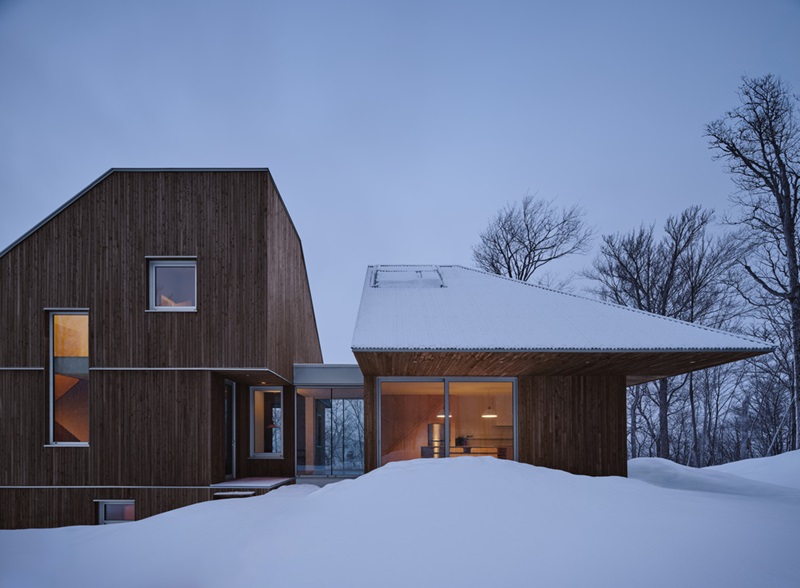 Julia-Manaças-Architecte-House-MN: casa de madera en el bosque nevado con cubierta a dos aguas