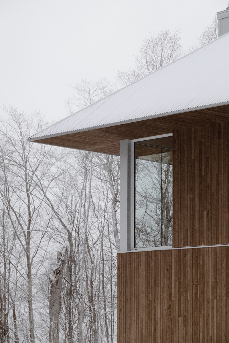 Julia-Manaças-Architecte-House-MN: casa de madera en el bosque nevado con cubierta a dos aguas