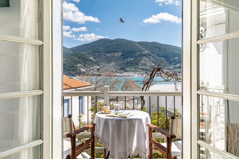 Airbnb: vistas al mar Egeo desde el balcón, con una mesa y dos sillas, de un alojamiento que se alquila en las islas griegas.