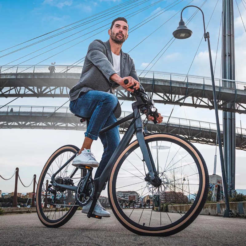 bicicleta eléctrica urbana: un hombre va de paseo por una vía asfaltada de la ciudad con la bicicleta eléctrica urbana C21 de Fiido