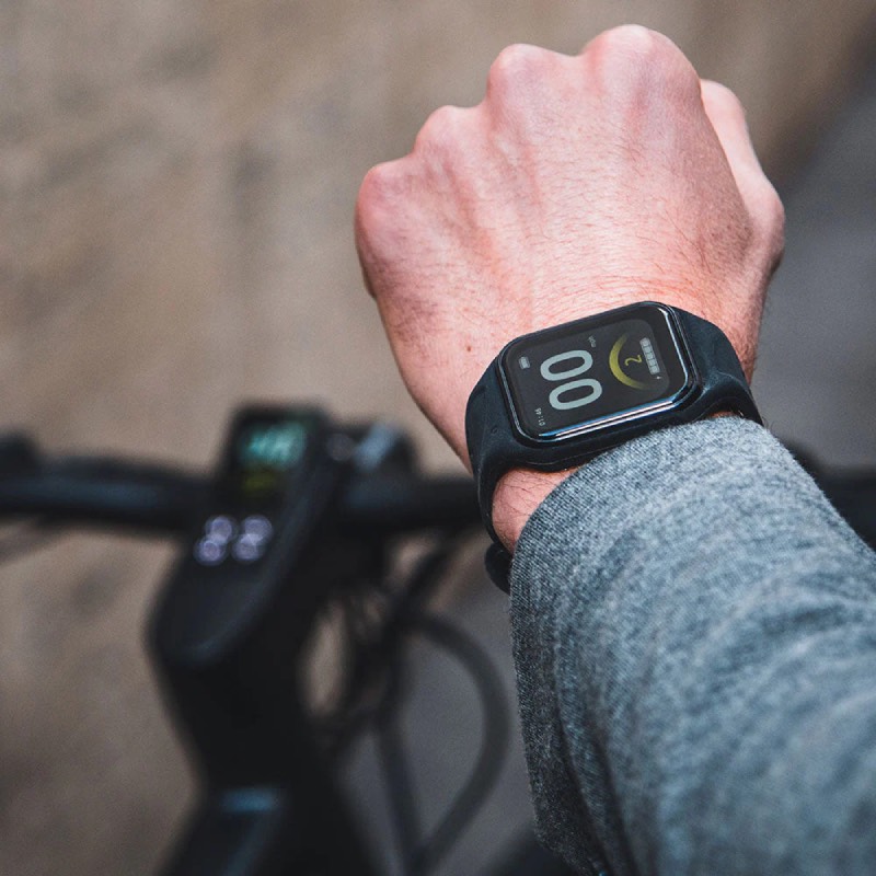 bicicleta eléctrica urbana: plano detalle de una mano de hombre con un reloj inteligente conectado a la bicicleta eléctrica urbana C21 de Fiido indicando parámetros como la marcha y la velocidad