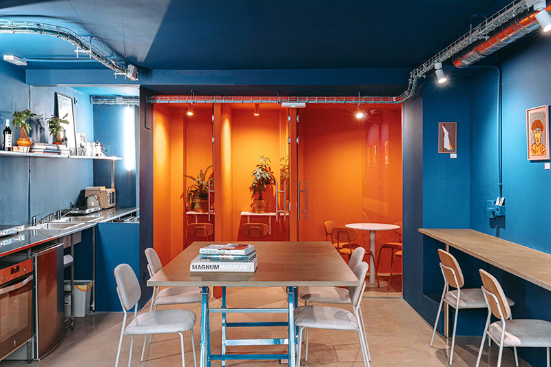 Eito coworking y cafetería: interior del local con las paredes pintadas de naranja y azul