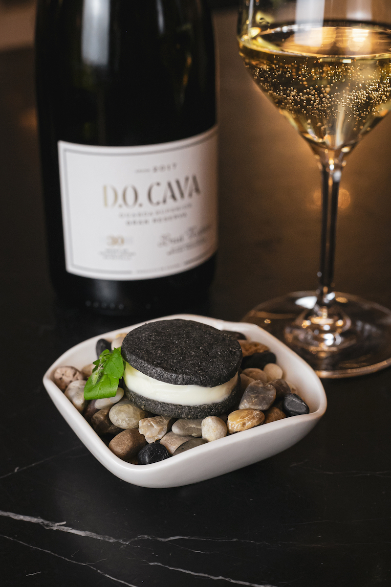 Hotel Wine Fest 2025: Oreo de parmesano. Crujiente de galleta con tinta de calamar rellena de crema de parmesano, de El Palace Barcelona