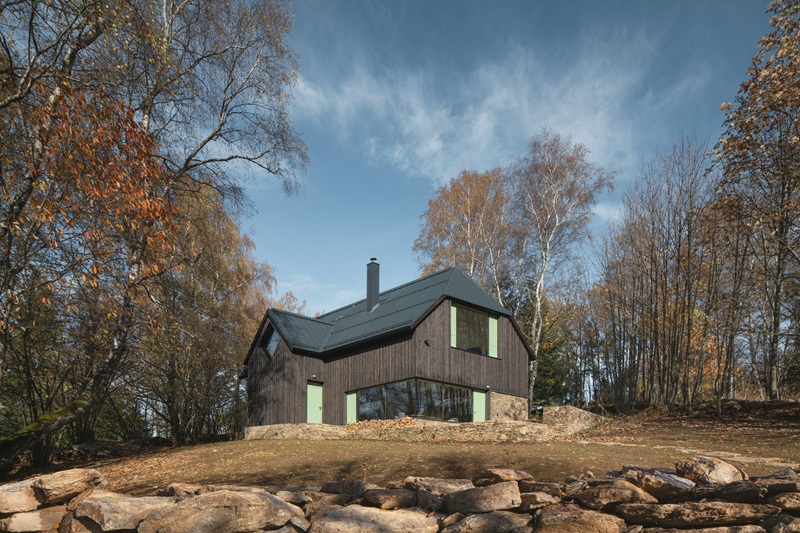 marketa-cajthamlova-cottage-in-sumava: casa de madera en la naturaleza con tejado inclinado