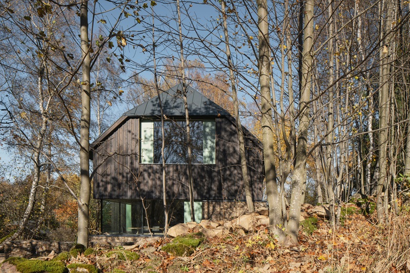 marketa-cajthamlova-cottage-in-sumava: casa de madera en la naturaleza con tejado inclinado