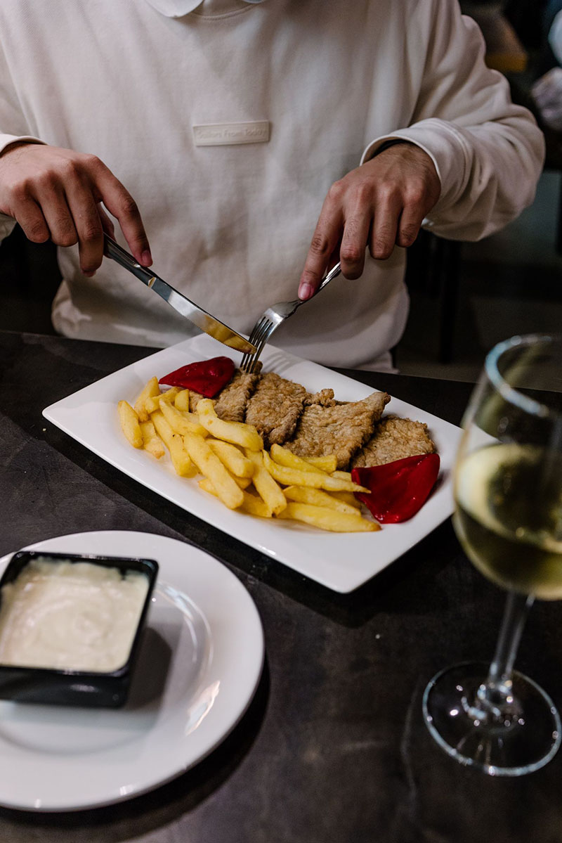 Mejores menús del día de Madrid: un hombre tomando un plato de carne en la Chalana