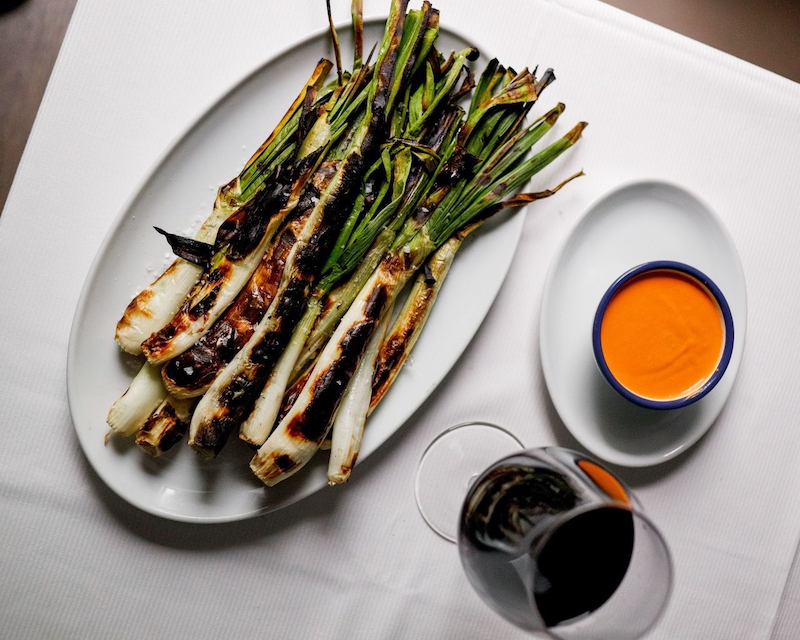 Restaurante Candeli menú: calçots, copa de vino y salsa romesco