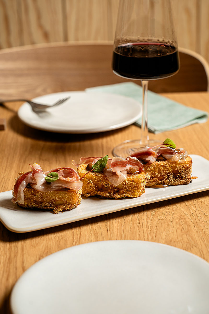 Restaurante Guiri Barcelona: plato del local maridado con una copa de vino