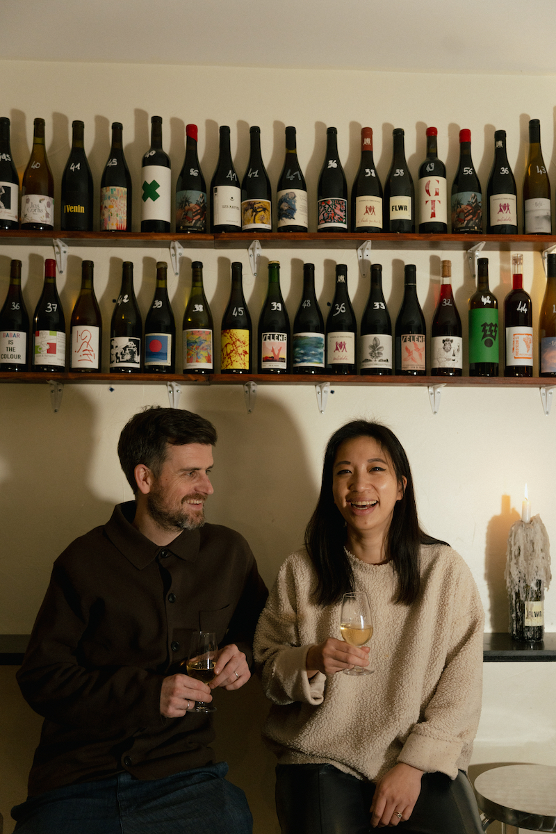 Restaurante Sobremesa: Marie y Emilien, los creadores del proyecto, con una estantería repleta de vinos detrás de ellos