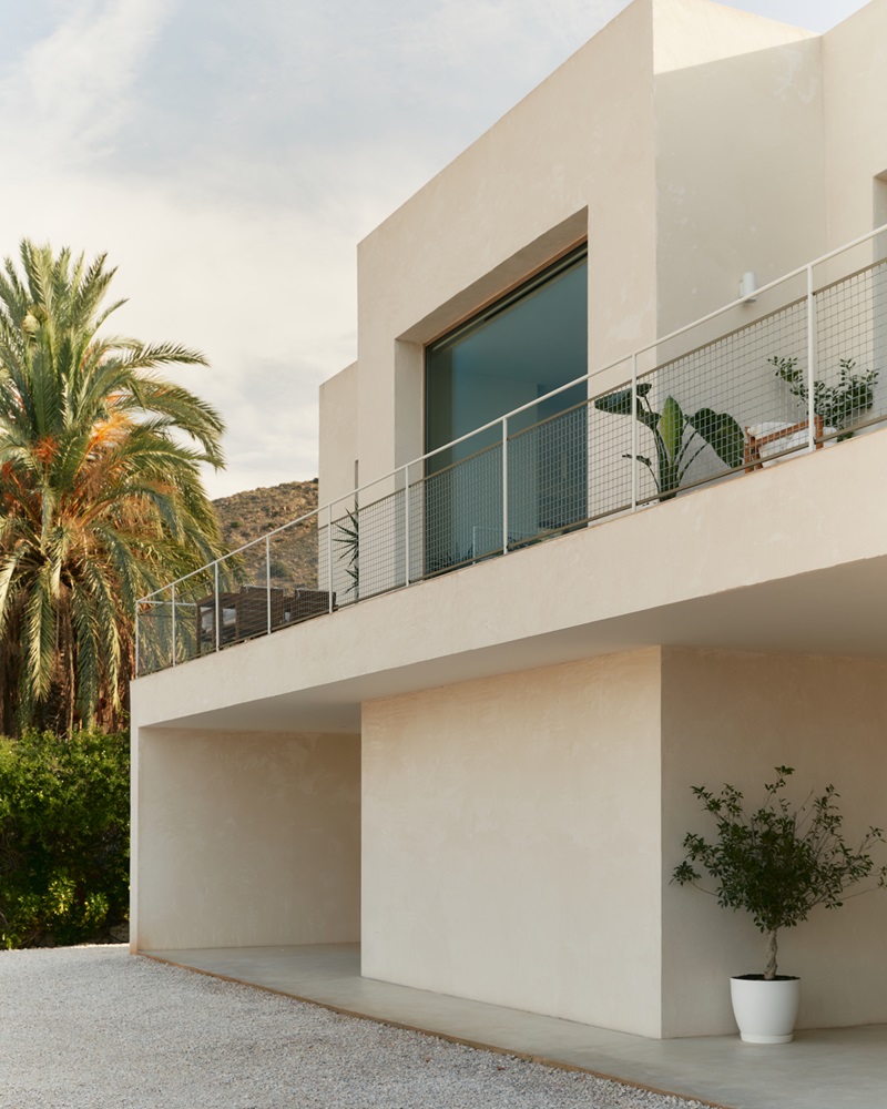 Abez-Casa-sobre-casa: fachada blanca con ventanal y terraza