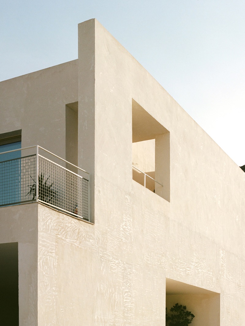 Abez-Casa-sobre-casa: fachada blanca con ventanal y terraza