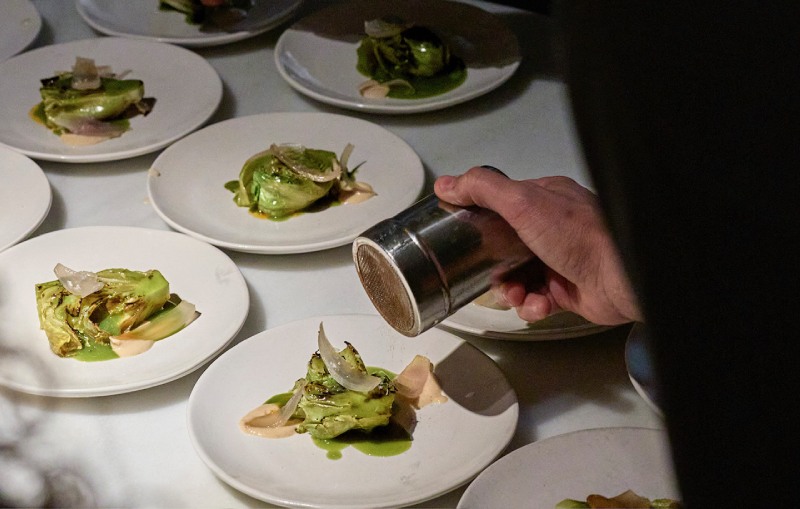 Cenas improvisadas Fismuler Barcelona: lechuga Maravilla a la brasa y una velouté de sus hojas licuadas, junto con pétalos de cebolla de Figueres a la brasa.