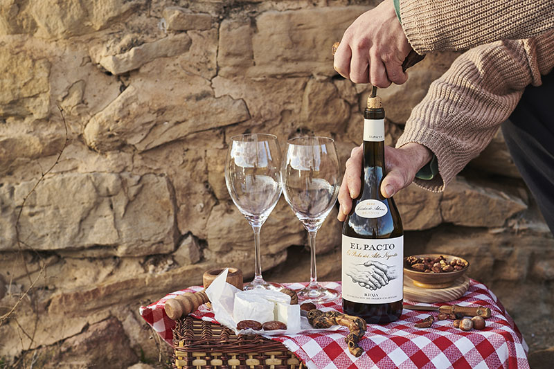 Mejores regalos San Valentín 2025: un hombre descorcha una botella de vino blanco