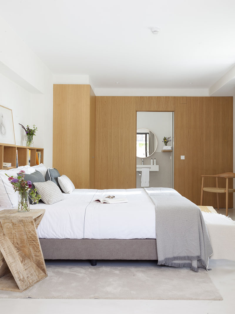 Dormitorio con decoración en tonos neutros, mobiliario de madera y una cama amplia, de Quinta San Francisco