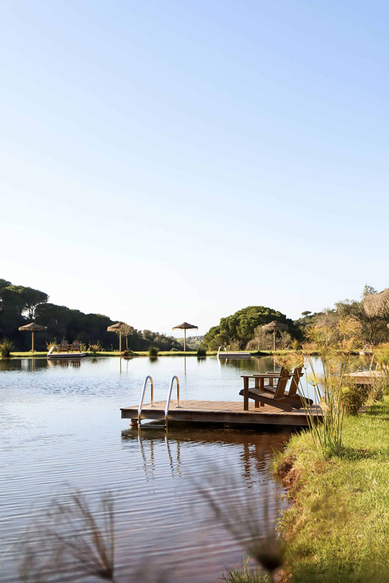 Laguna con embarcadero y tumbonas en Wecamp Reserva Alecrim