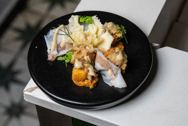 Barcelona concurso queso suizo: Contracorrent presenta una coca de polenta crujiente con Tête de Moine AOP, calçots, guanciale y romesco de tomate seco.