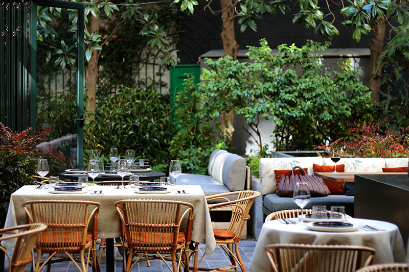 Restaurante Tragaluz en Madrid: vista del jardín con sillas de ratán